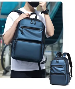 Deep blue water-resistant backpack showing outdoor use and multi-pocket storage detail
