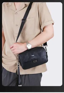 Close-up of black leather crossbody bag with kangaroo logo on khaki shirt