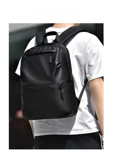 Outdoor shot showing side view of a large black minimalist laptop backpack being worn