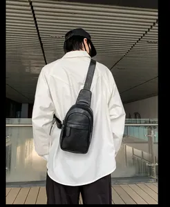 Mann trägt schwarze Leder-Brusttasche über weißem Hemd, Rückansicht der Umhängetasche