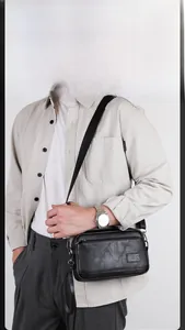 Close-up of black leather crossbody bag with lychee texture and adjustable strap