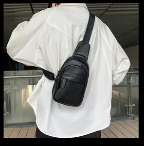 Detailansicht einer schwarzen Leder-Brusttasche getragen von einem Modell im Freien