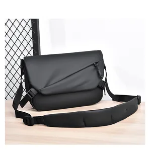 Détail du sac à bandoulière noir mat avec bandoulière rembourrée et poche zippée devant