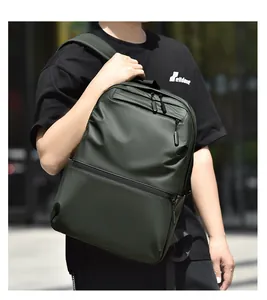 Detail of olive green backpack showing the matte waterproof fabric and front zipper pocket
