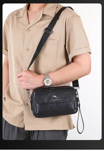 Detail of black faux leather crossbody bag showing kangaroo logo and pebble texture