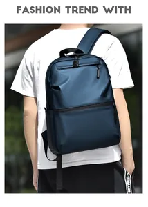 Detail view of water-resistant navy blue laptop backpack worn by a model in outdoor setting