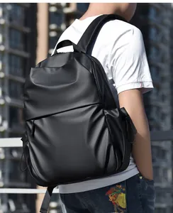 Side view of a minimalist black waterproof laptop backpack worn by a model in the city