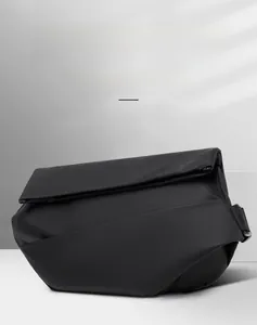 Detail of minimalist black crossbody bag showing matte waterproof fabric and metal buckle