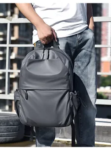 Detail of dark gray minimalist backpack showing water-resistant fabric and side pocket