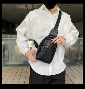 Moderne schwarze Leder-Umhängetasche für Herren über einem weißen Hemd im minimalistischen Stil