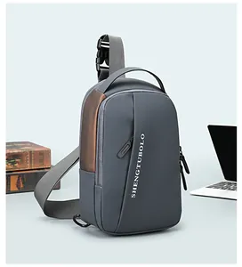Detail of dark grey tech chest bag with bronze stitching and adjustable buckle strap
