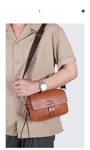 Brown leather crossbody bag with lychee texture and metal buckle shown on a model