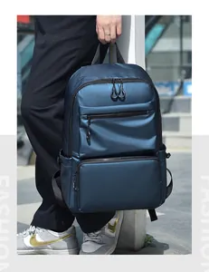 Detail of dark blue waterproof backpack featuring multiple zipper compartments and top handle