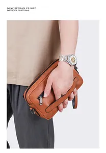 Brown leather textured men's clutch bag with silver zipper detail and wrist strap