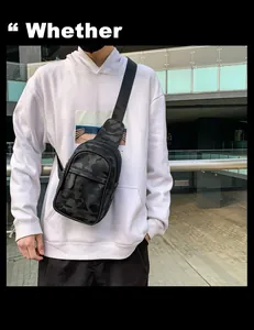Detailansicht einer dunklen Camouflage-Brusttasche für Herren über einem weißen Hoodie