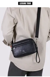 Detail einer schwarzen Umhängetasche aus Leder mit Gurt und strukturierter Oberfläche
