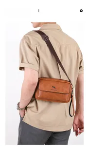 Rear view of brown leather crossbody bag with adjustable strap and kangaroo logo detail