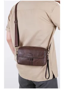Close-up of brown textured leather men shoulder bag with adjustable strap and metal buckle