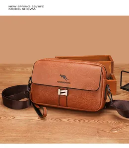 Detailed macro view of the brown lychee grain leather texture and kangaroo logo on the bag