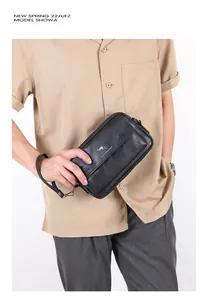 Detail of black leather men's clutch featuring embossed kangaroo logo and fine texture