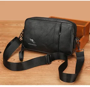 Detail of black pebbled PU leather texture and kangaroo logo on men's crossbody bag