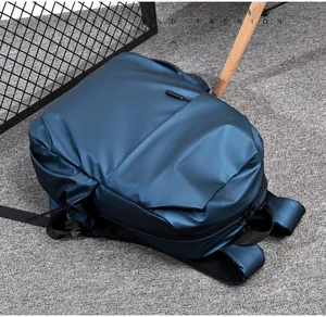 Detail view of water-resistant deep blue laptop backpack on a grey carpet background