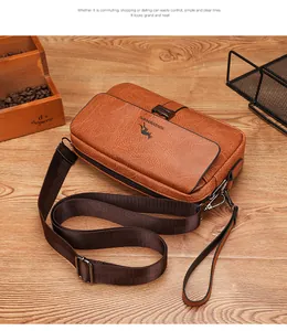 Detailed view of brown lychee grain leather crossbody bag with adjustable strap on wooden table