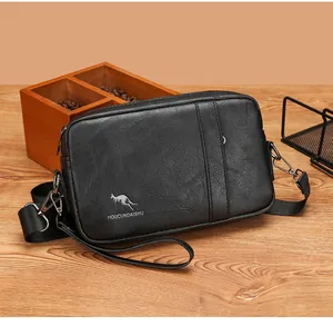 Detail of black leather men's messenger bag with silver logo on wooden background