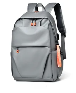 Macro detail of waterproof grey backpack featuring USB charging port and orange zipper