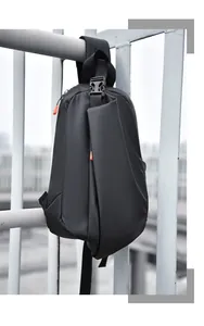 Detail view of water-resistant black crossbody bag featuring vibrant orange zipper pulls