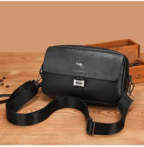 Detail of lychee textured leather crossbody bag with metal buckle and adjustable strap