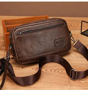 Macro detail of dark brown retro leather crossbody bag with metal zipper and HCDS patch