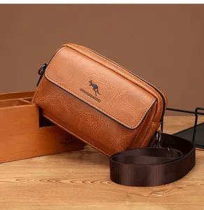 Detail of brown leather messenger bag featuring pebble grain texture and kangaroo logo