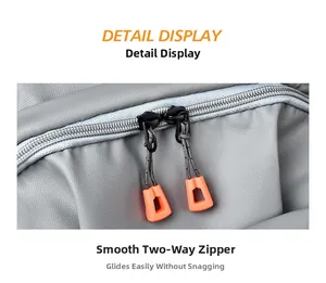 Detail of smooth two-way zippers with orange pulls on grey nylon business backpack