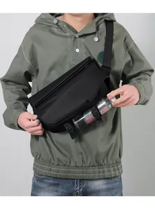 Detail showing the adjustable bottom straps holding a water bottle on the black crossbody bag