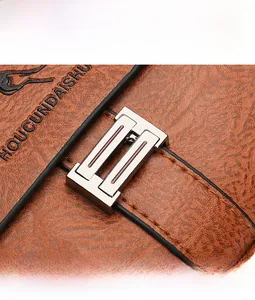 Detail of silver metallic lock and textured brown leather on men's crossbody bag