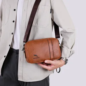 Brown faux leather crossbody bag for men with a wide nylon strap and classic metal zipper