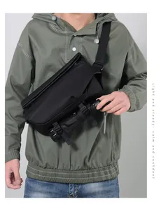 Detail view of large messenger bag showing adjustable buckle straps securing an umbrella