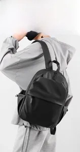 Close-up of minimalist black travel backpack featuring waterproof matte fabric and hidden zippers