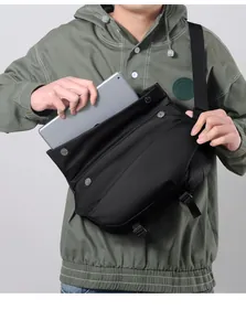 Detail showing the large capacity of the black crossbody bag fitting a tablet computer
