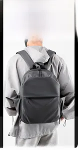 Close-up of the ergonomic shoulder straps and side pocket on a dark gray laptop backpack