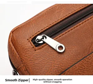 Detail shot of smooth silver metal zipper and neat stitching on brown textured leather bag