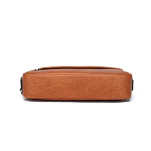 Bodenansicht der braunen Messenger-Tasche aus PU-Leder mit Lychee-Struktur und Hardware