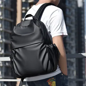 Minimalist black waterproof laptop backpack shown on model in urban city setting