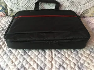 Détail frontal de la sacoche noire pour ordinateur avec bande rouge et tissu durable