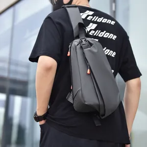 Urban black tactical crossbody chest bag with orange zipper detail worn by male model