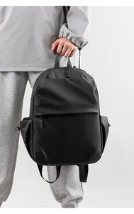 Close-up of minimalist black laptop backpack with matte waterproof texture and sturdy handle