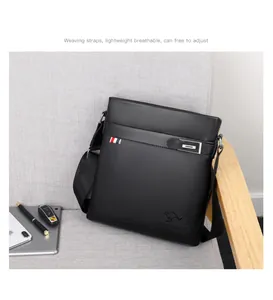 Detail of black lychee grain leather briefcase with woven strap on a grey fabric chair