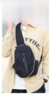 Men's matte black nylon sling bag with vertical zipper shown on casual outfit