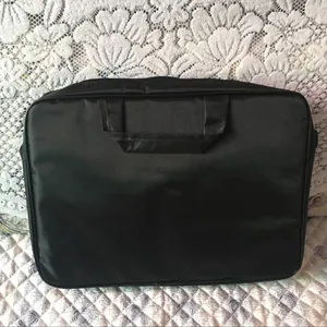 Sacoche d'ordinateur noire minimaliste avec poignées doubles et surface en nylon durable